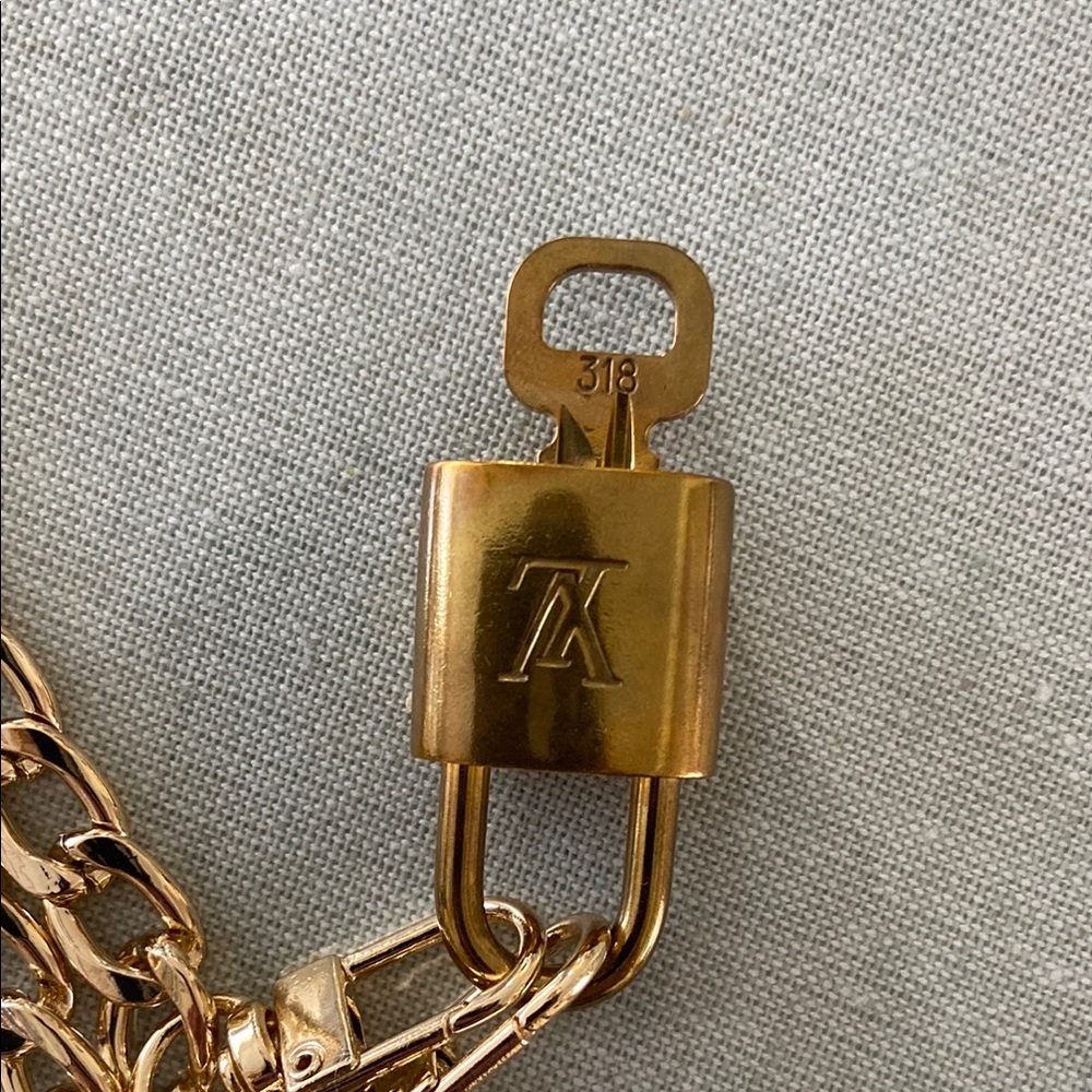 Authentic Louis Vuitton Gold Lock and Key.  Unbranded light gold chain. LV Tag